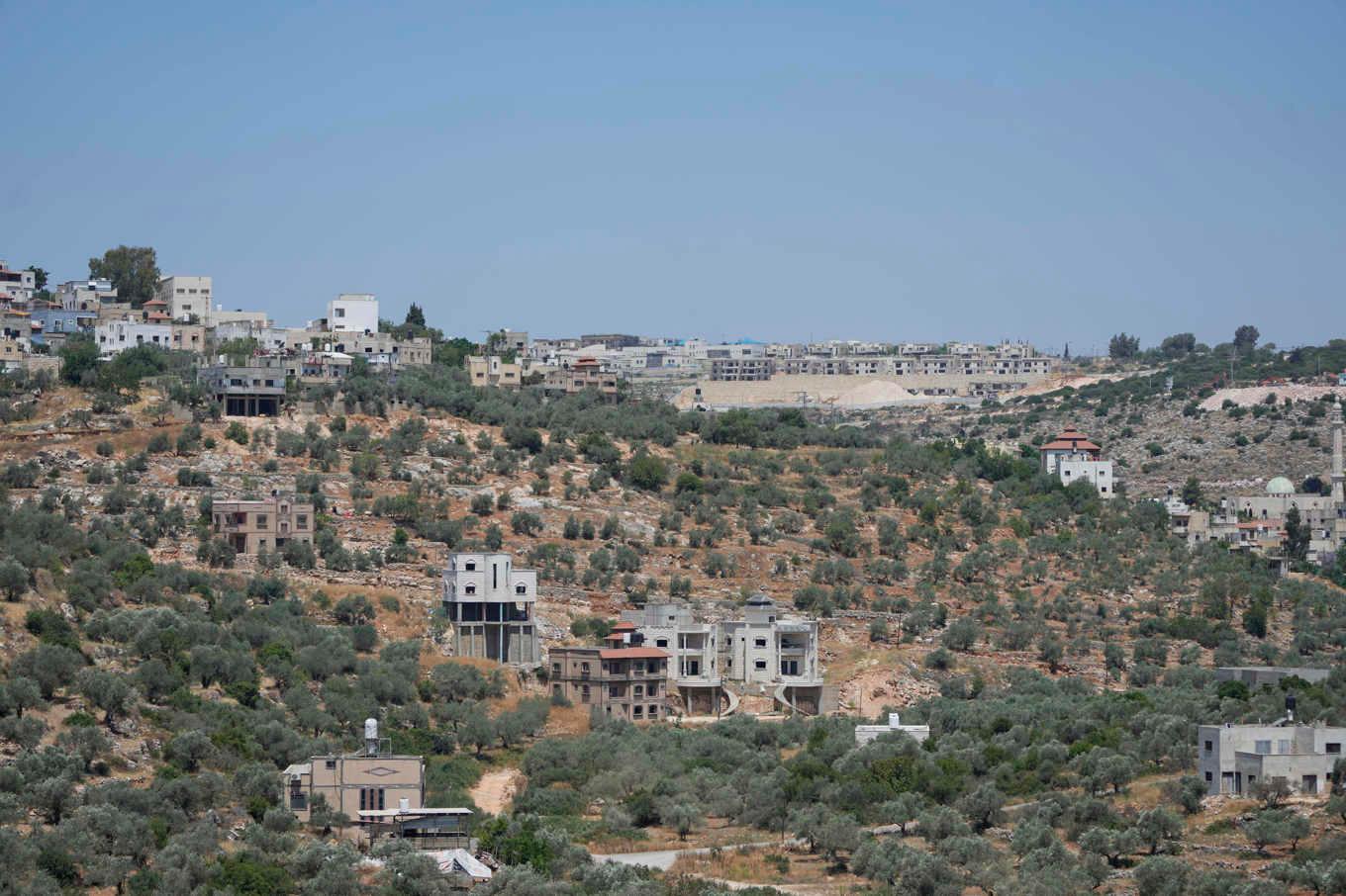 En israelisk bosättning i Bruchin på Västbanken samt byn Bruqin. Arkivbild. Foto: Nasser Nasser/AP/TT