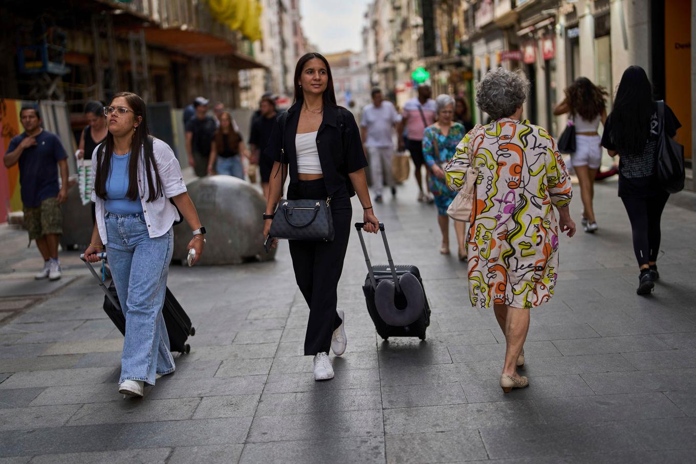 FILE - Tourists carry their luggage in downtown Madrid, Spain, June 3, 2025. (AP Photo/Manu Fernandez, File)  RPSN101 Foto: Manu Fernandez/AP