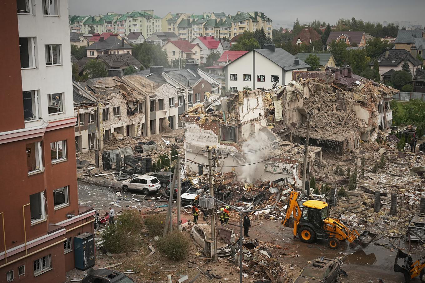 Räddningsinsatser pågår vid ett flerfamiljshus som förstördes helt i attacken i Kiev på söndagen. Foto: Efrem Lukatsky/AP/TT