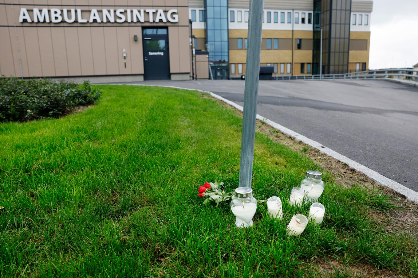 Blommor och ljus utanför ambulansstationen i Region Gävleborg i Hudiksvall, dagen efter att en ambulanssjukvårdare blivit dödad i tjänsten i Harmånger i Nordanstig kommun. Foto: Mats Andersson/TT