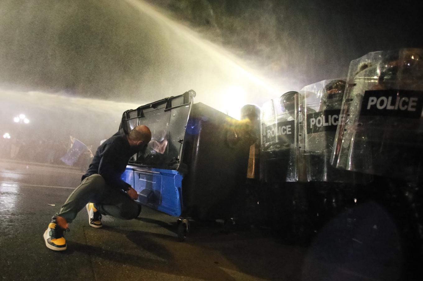 En demonstrant skyddar sig bakom en soptunna under de våldsamma demonstrationerna i Tbilisi. Foto: Zurab Tsertsvadze/AP/TT