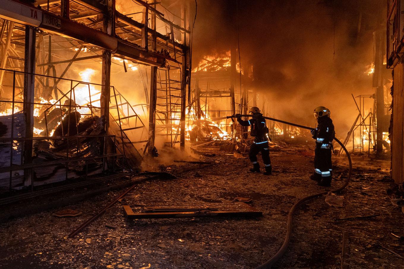 Räddningspersonal släcker bränder efter en tidigare rysk flygattack mot Charkiv i början av oktober. Foto: Andrii Marienko/AP/TT