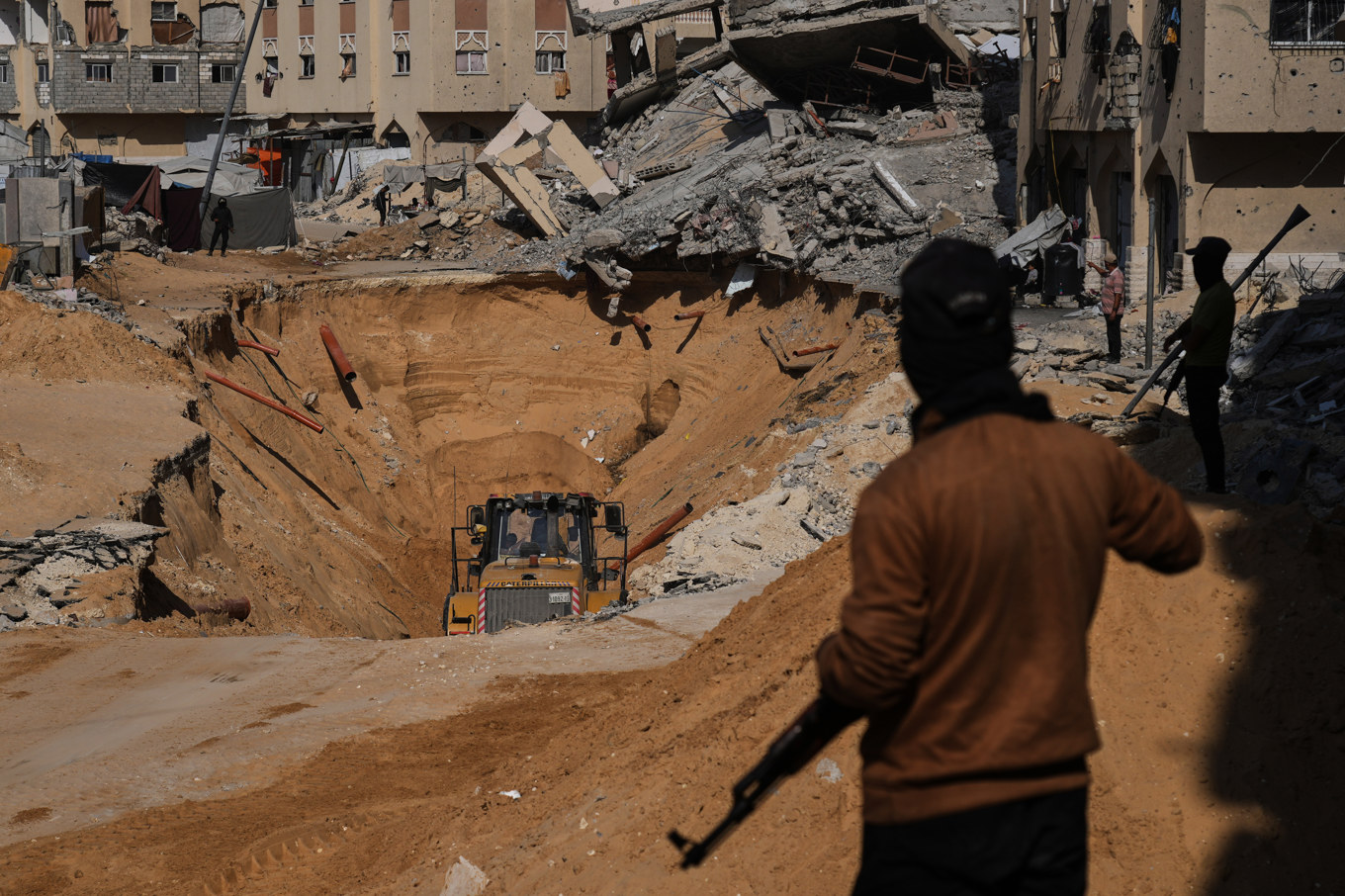 Medlemmar i Hamas söker efter kvarlevor efter döda israeliska gisslan bland förstörda byggnader i Khan Yunis, i södra Gaza. Foto: Abdel Kareem Hana/AP/TT