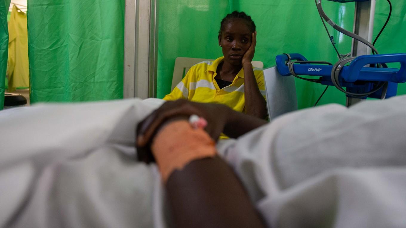 En kvinna tittar på sin bror Noel Davidson, en 22-åring som skadades av ett skott i huvudet under gängrelaterat våld, på Drouillard-sjukhuset i Cite Soleil-distriktet i Port-au-Prince den 12 december 2024. Foto: Clarens Siffroy/AFP via Getty Images