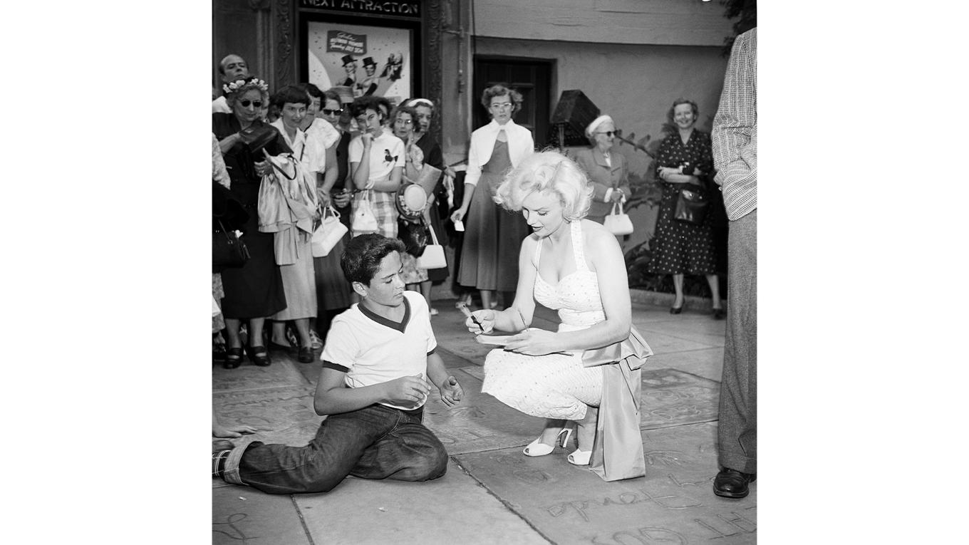 Marilyn Monroe (1926–1962) skriver en autograf till en beundrare utanför Grauman’s Chinese Theatre i Hollywood, Kalifornien, den 26 juni 1953. Foto: Getty Images