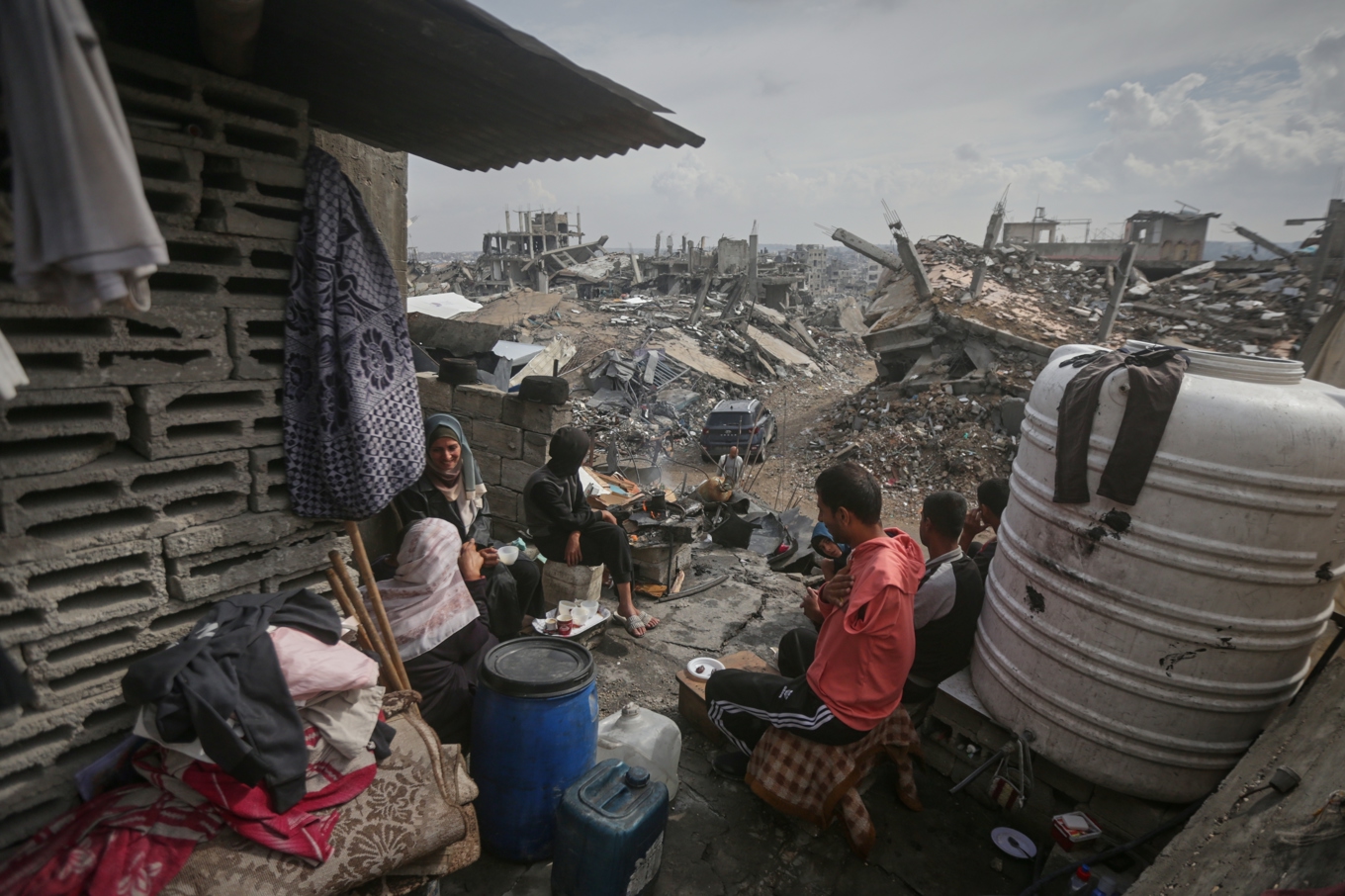 Den palestinska familjen Atallah sitter i resterna av sitt hem i sönderbombade Gaza stad. Foto: Yousef Al Zanoun/AP/TT