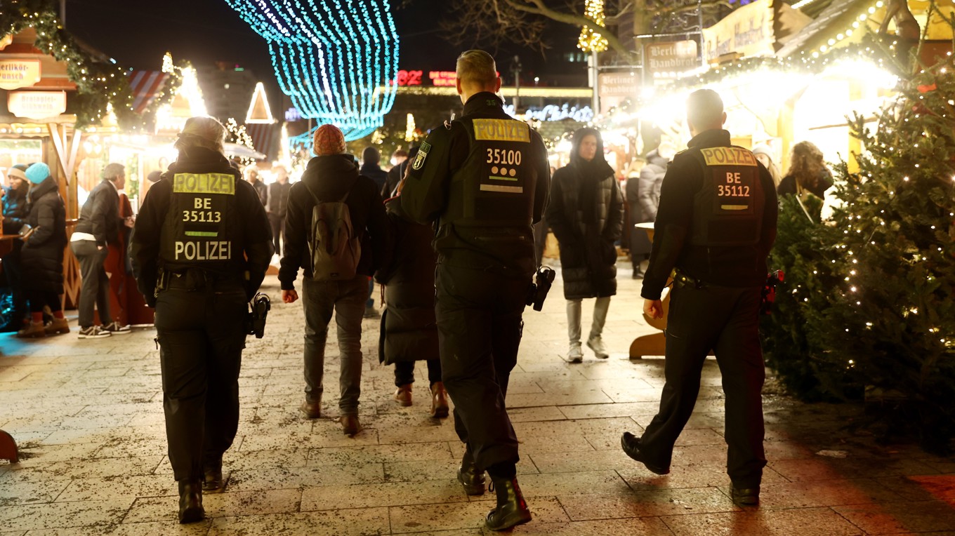 Poliser patrullerar medan besökare promenerar bland julmarknadsstånden på öppningsdagen för den årliga julmarknaden på Breitscheidplatz i Berlin den 24 november. Foto: Maryam Majd/Getty Images