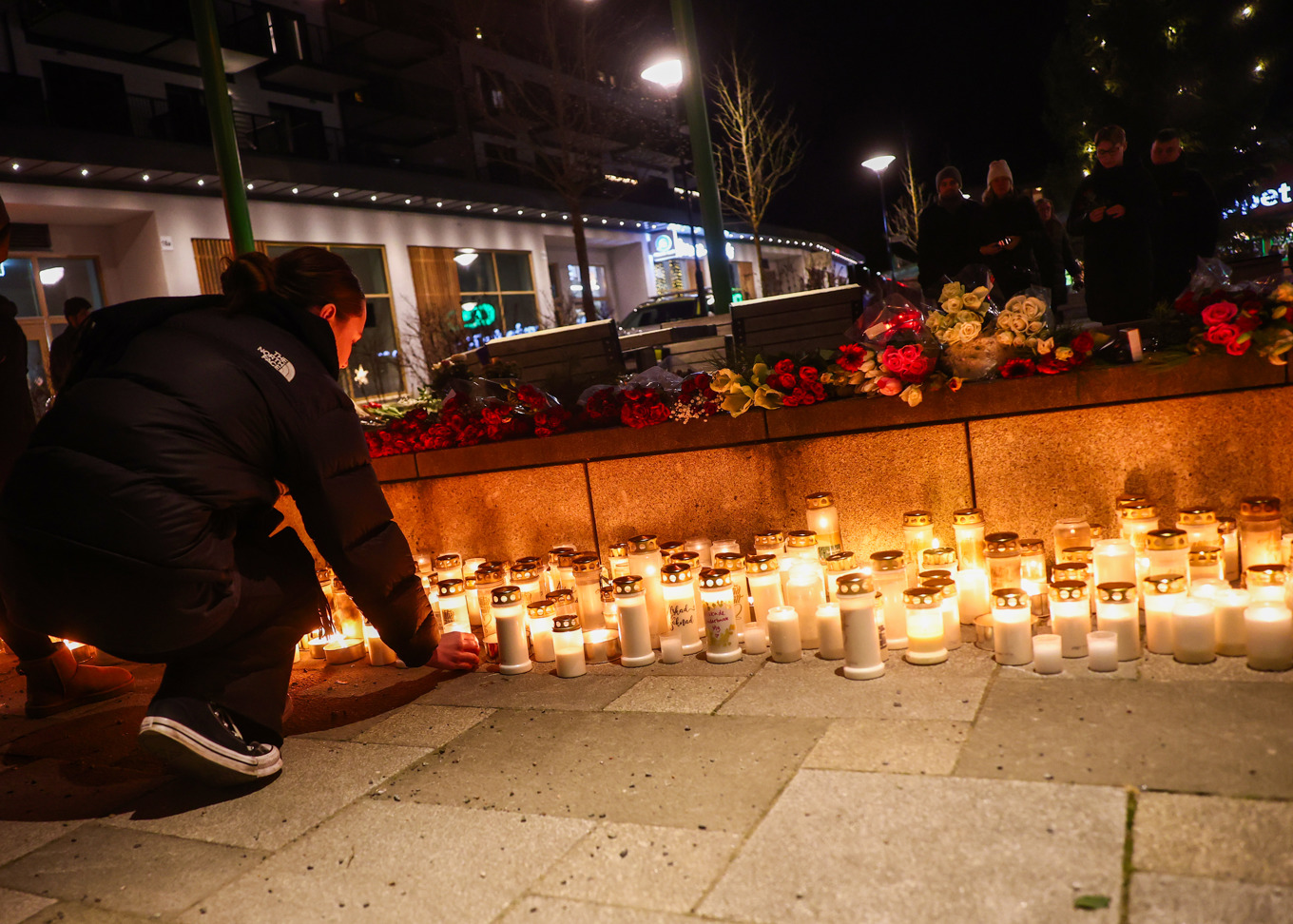 Människor lämnar blommor och tänder ljus till minne av den kvinna som försvann från pendeltågsstationen i Rönninge. Foto: Nils Petter Nilsson/TT