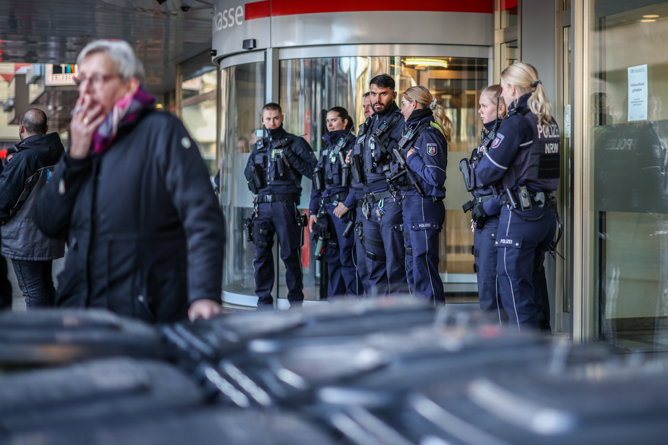 Poliser står framför banken där rånet ägde rum. Foto: Christoph Reichwein/APA via AP/TT