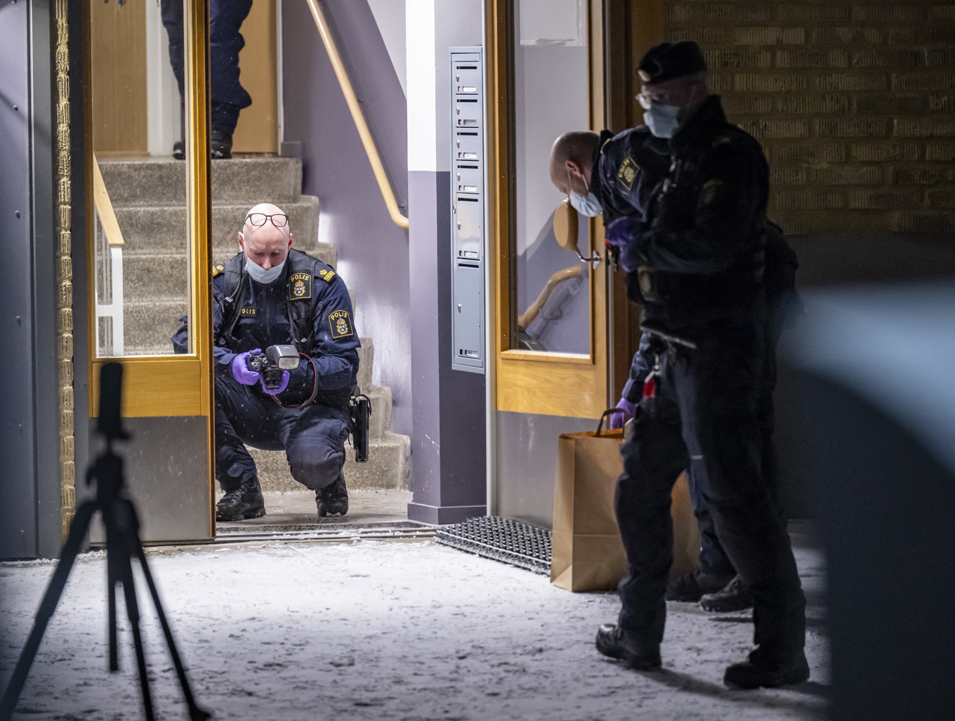 Polis och kriminaltekniker på plats vid det flerfamiljshus i Helsingborg där en kvinna skadats i samband med ett hemvårdsbesök. Foto: Johan Nilsson/TT