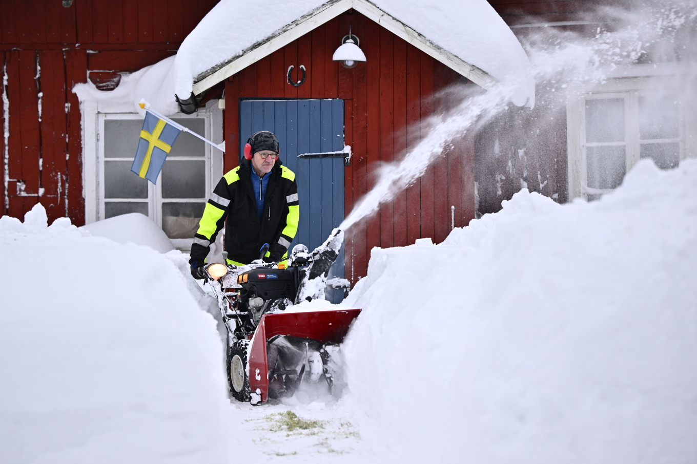 Börje Löfgren i Råhällan, mellan Gävle och Ockelbo, skottar fram gäststugan genom den meterhöga snön sedan han återfått strömmen efter stormen Johannes. Foto: Anders Wiklund/TT