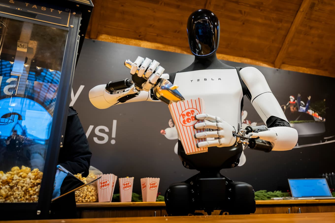 Tesla satsar på bland annat roboten Optimus, som här serverar popcorn på ett jippo i Tyskland nyligen. Foto: Christoph Soeder/DPA via AP/TT