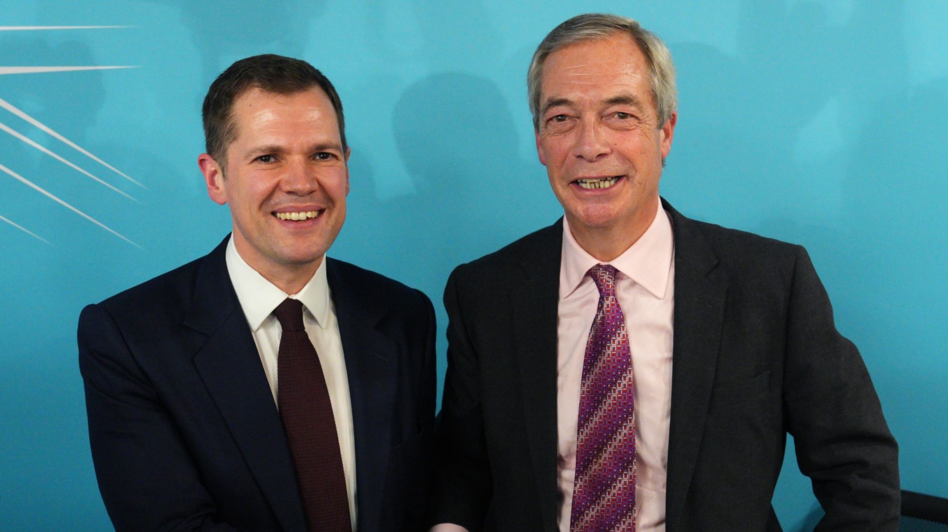 Robert Jenrick (till vänster) och Nigel Farage, partiledare för Reform UK, hälsar på varandra i samband med en presskonferens den 15 januari i London. Foto: Carl Court/Getty Images