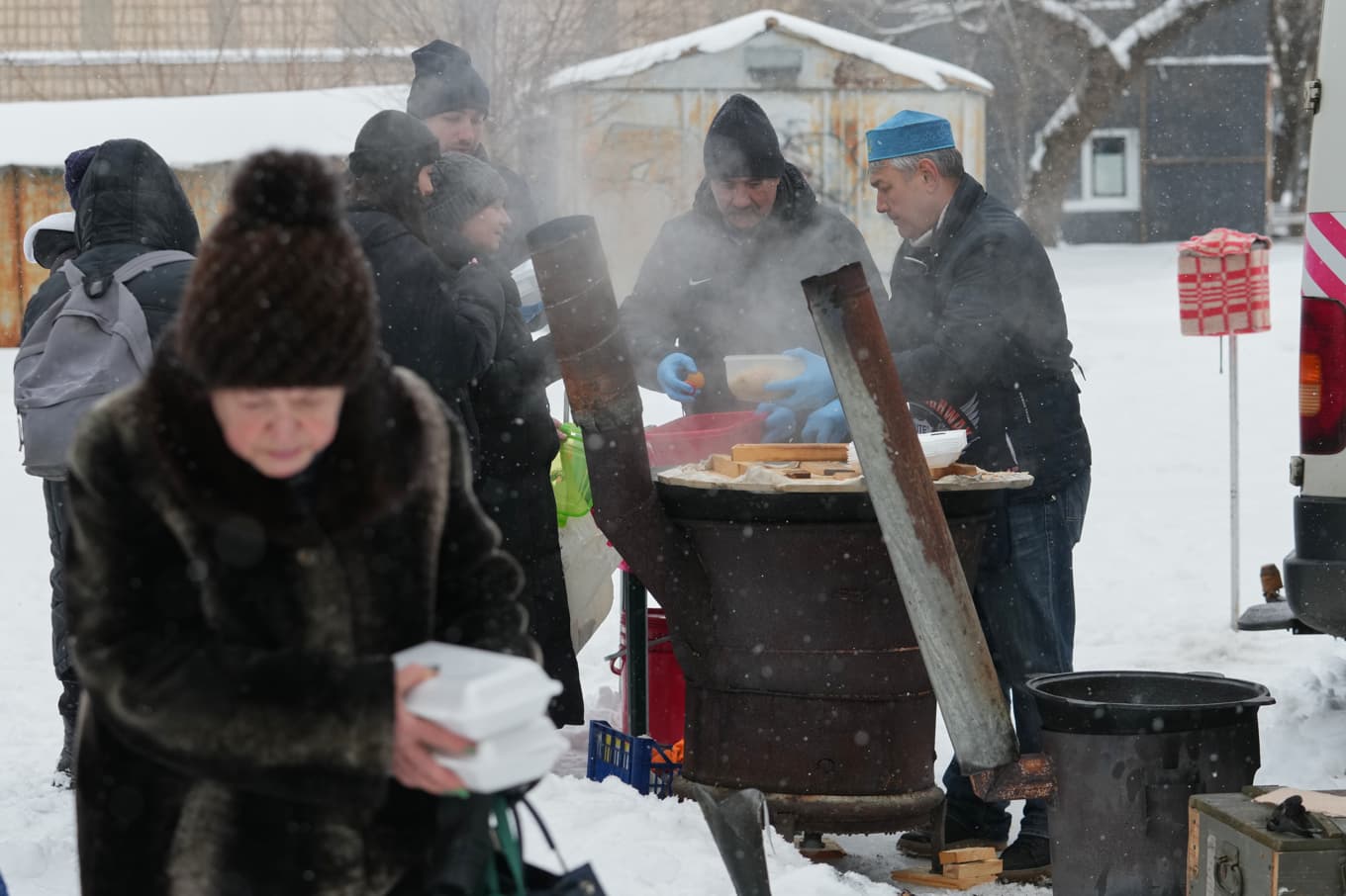 Volontärer serverar varm mat till invånarna i Kiev under ett av de många strömavbrotten till följd av ryska attacker. Foto: Sergei Grits /AP/TT