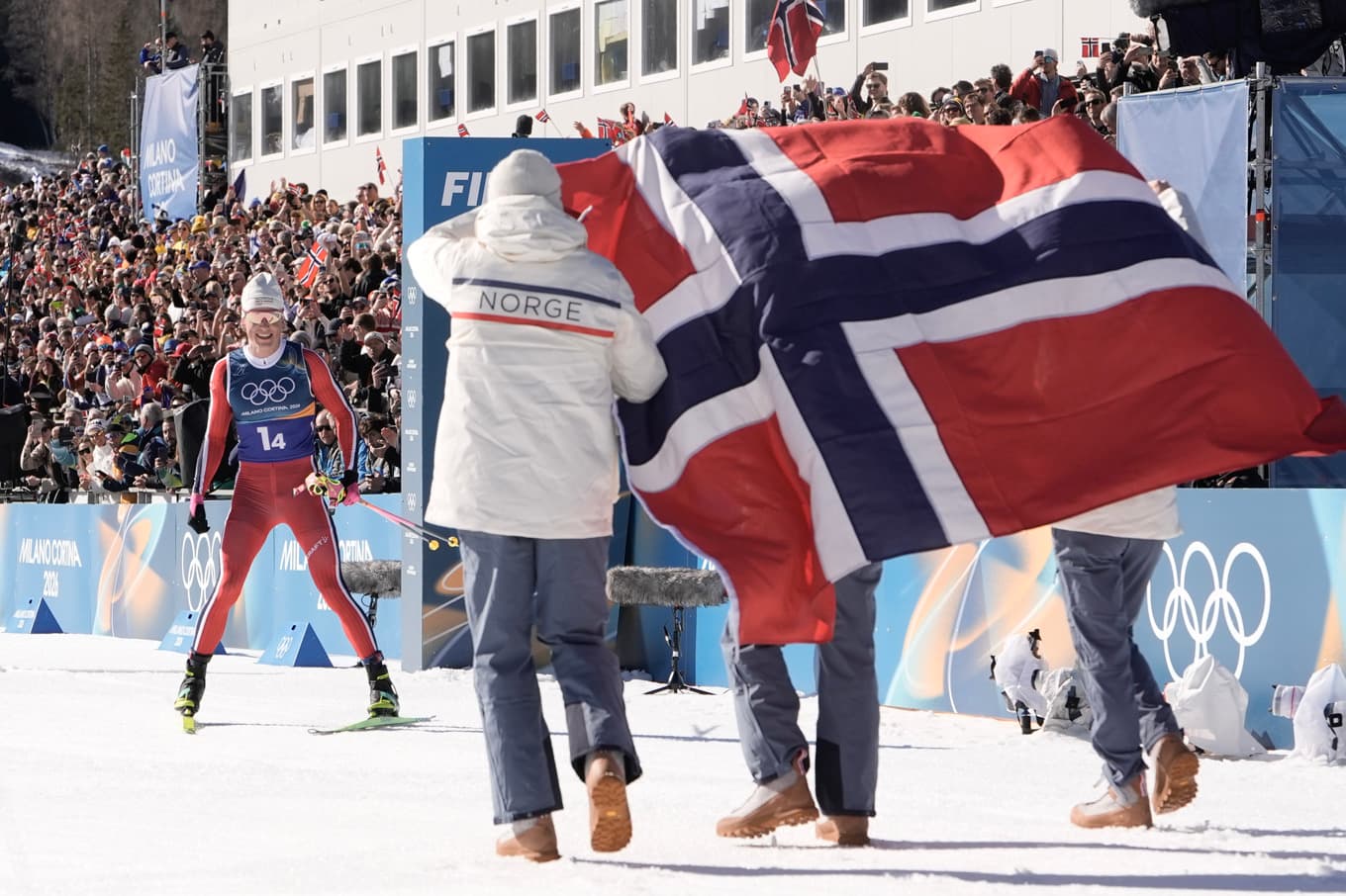 Johannes Høsflot Klæbo tas emot av lagkompisarna i det norska stafettlaget efter att ha bärgat sitt nionde OS-guld i karriären. Foto: Terje Pedersen/NTB/TT