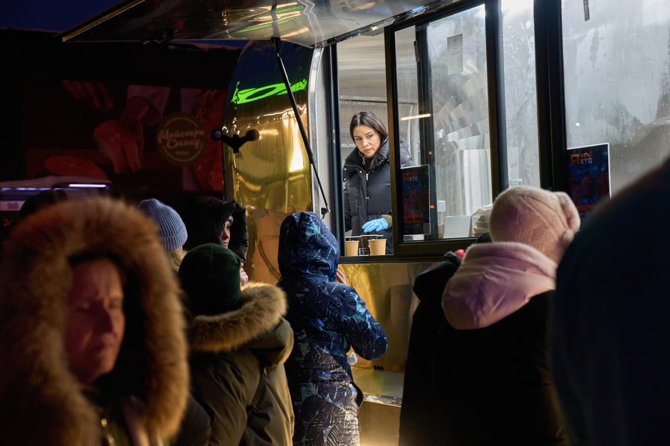 Invånare väntar på att få värmd mat serverad av Ukrainas militär i Kiev, där el- och värmebrist är akut för många boende. Foto: Efrem Lukatsky  /AP/TT