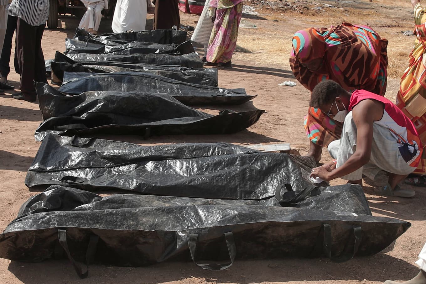 Sudaneser letar efter dödade anhöriga sedan Röda Korset transporterat krigsoffer från tillfälliga gravar till en begravningsplats i huvudstaden Khartum i januari. Foto: Marwan Ali/AP/TT