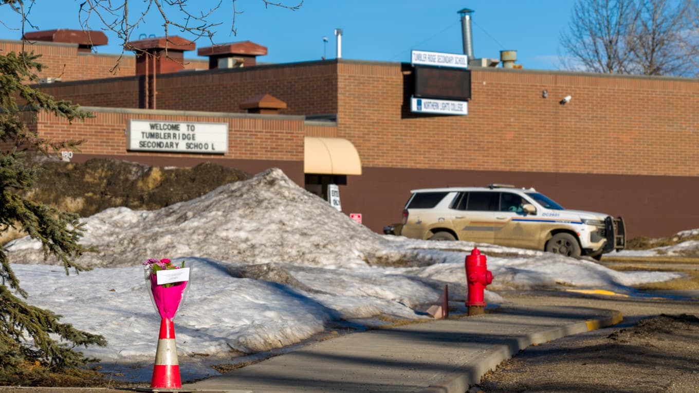 Blommor har lämnats utanför Tumbler Ridge Secondary School-byggnaden i Kanada där en dödlig skottlossning ägde rum. Foto av Eagle Vision Agency/AFP via Getty Images