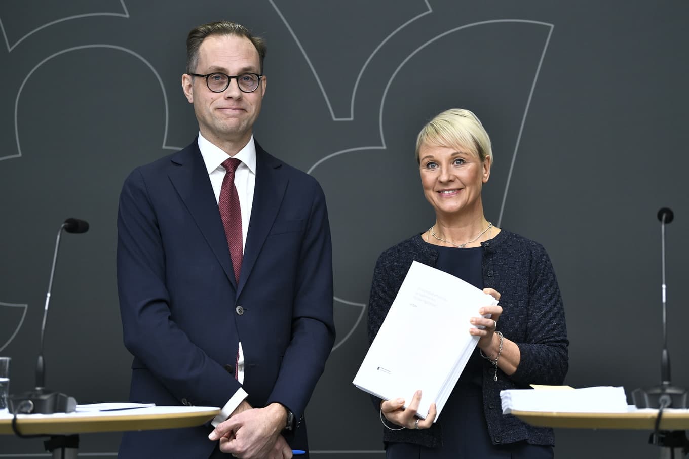 Socialförsäkringsminister Anna Tenje (M) tar under en pressträff emot en utredning om en effektivare ordning för att bekämpa bidragsbrott från regeringens utredare Mikael Westberg. Foto: Lars Schröder/TT