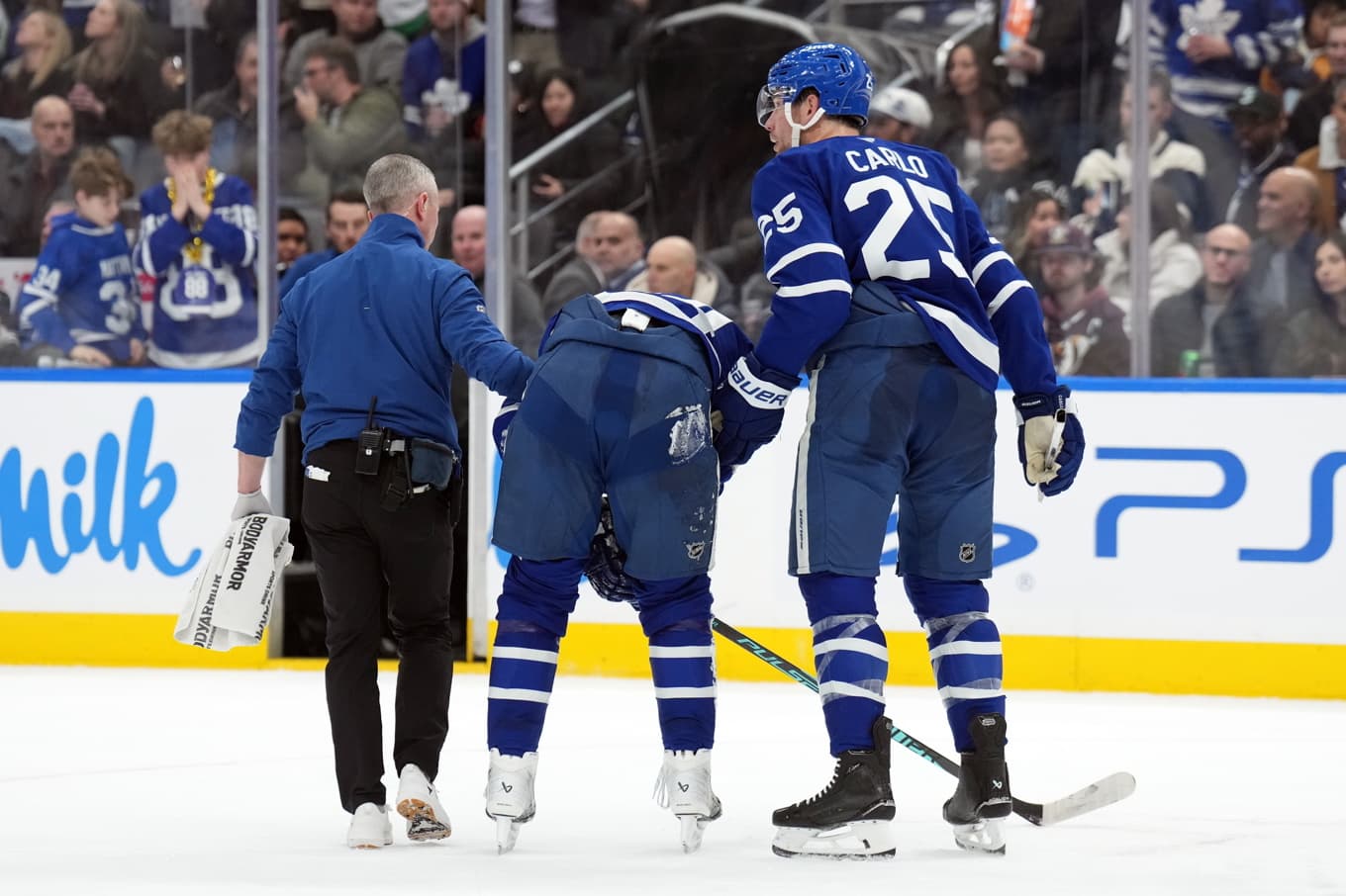 Torontos lagkapten Auston Matthews får hjälp att lämna isen efter att ha åkt på en knätackling. Foto: Nathan Denette/AP/TT