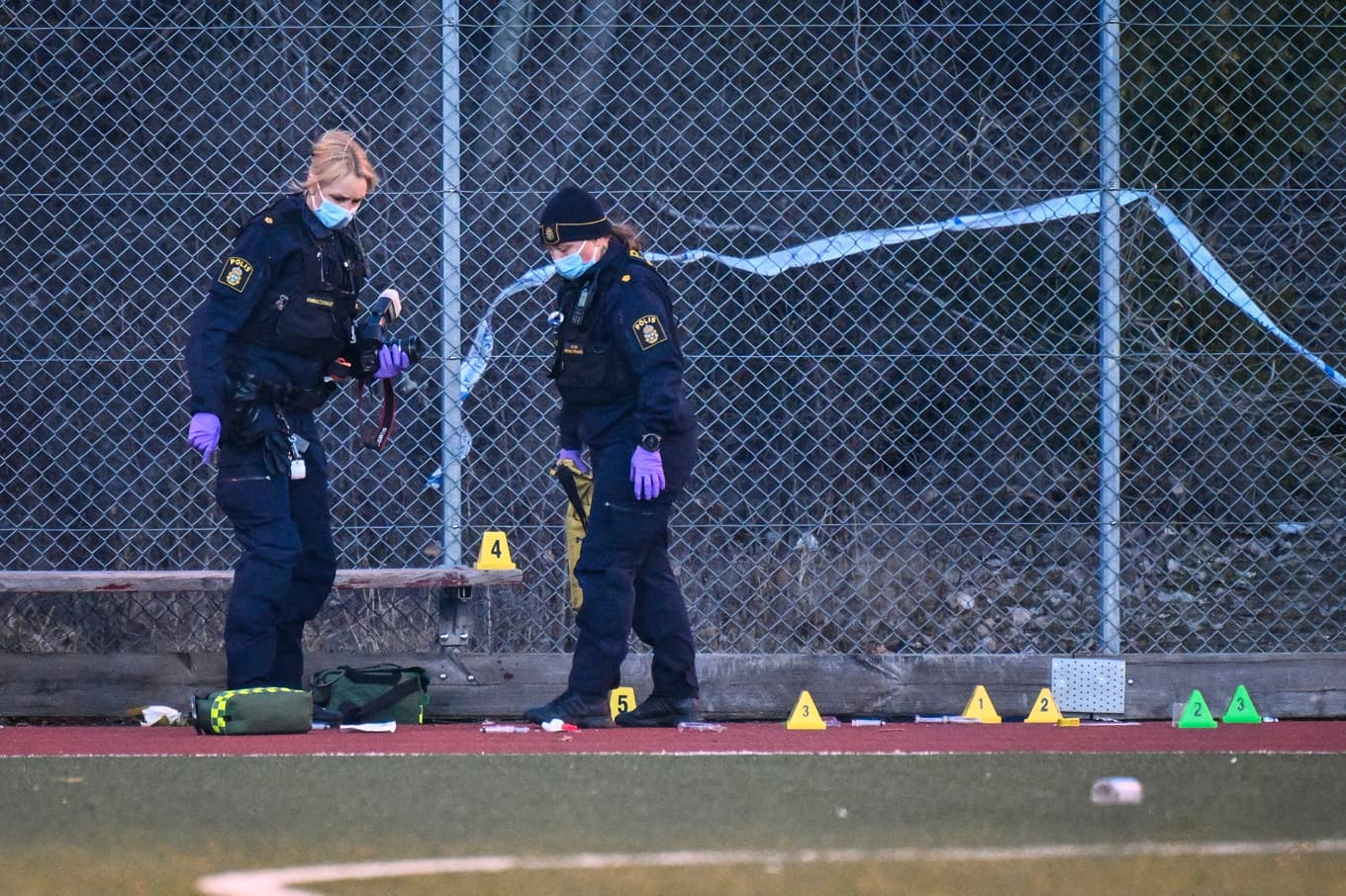 Polis på plats vid en fotbollsplan i stadsdelen Vårby Gård i Huddinge, söder om Stockholm sedan en man hittades skjuten på måndagseftermiddagen. Foto: Jessica Gow/TT