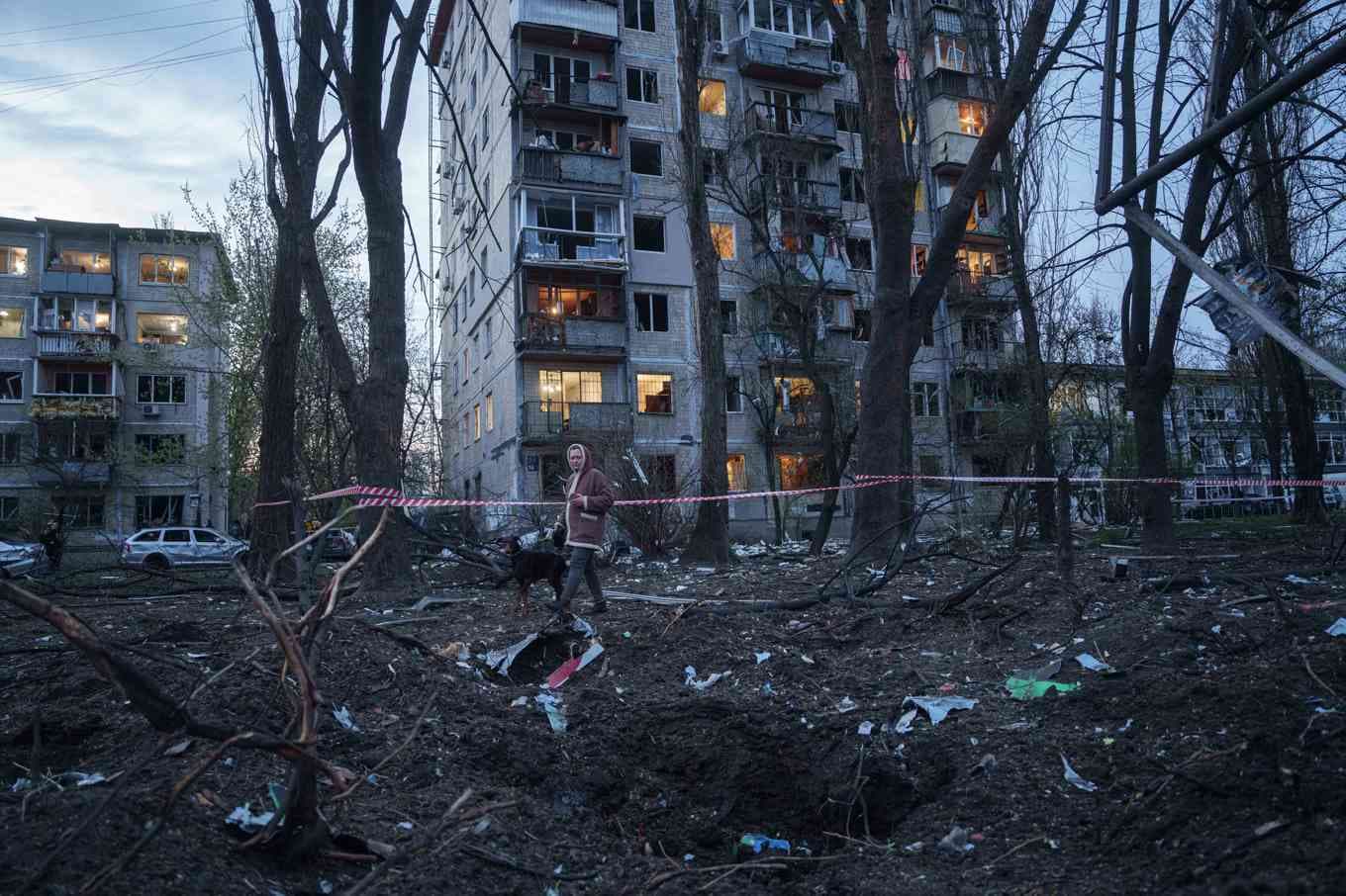 En kvinna promenerar bland bråte efter en rysk attack mot ett bostadsområde i Kiev. Foto: Evgeniy Maloletka/AP/TT