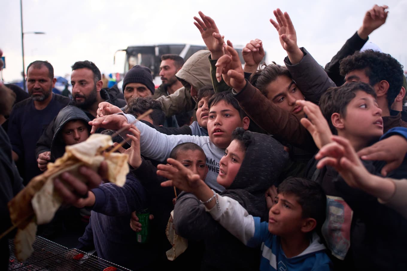 Barn och vuxna på flykt från södra Libanon väntar på donerad mat i Beirut den 9 april. Foto: Emilio Morenatti/AP/TT