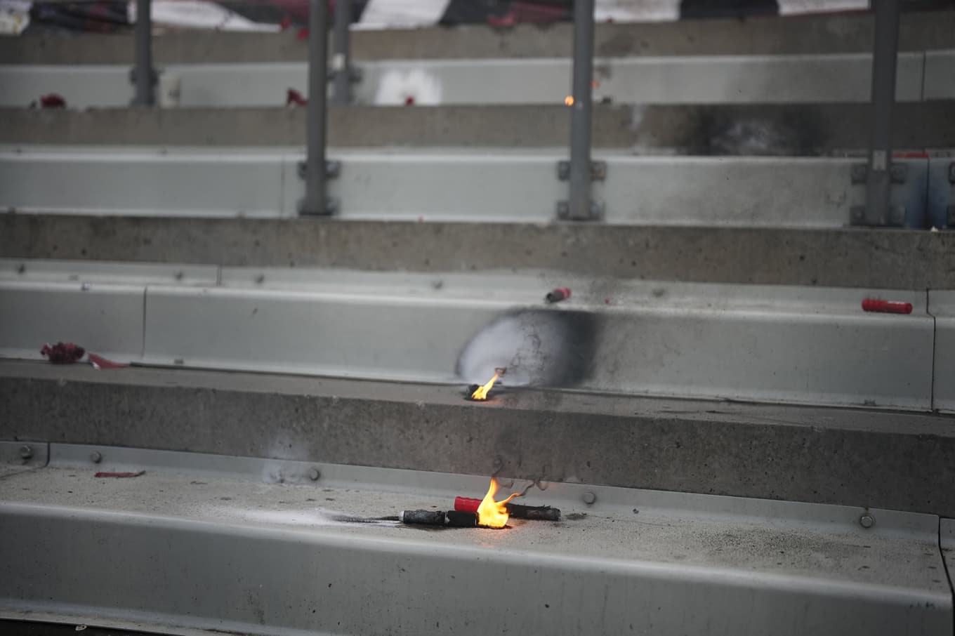 Brinnande pyroteknik på läktaren efter den avbrutna matchen. Foto: Björn Larsson Rosvall/TT