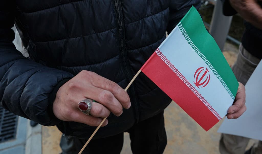 En man håller i Irans flagga. Foto: Courtney Bonneau / Middle East Images / AFP via Getty Images