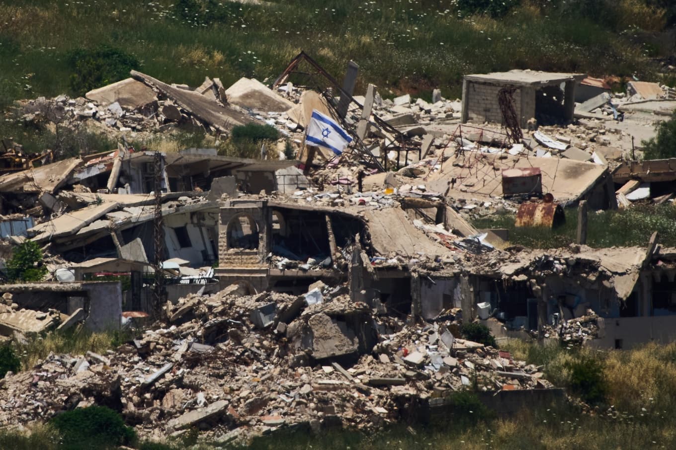 En israeliska flagga på en förstörd byggnad i södra Libanon. Bild från i torsdags. Foto: Ariel Schalit  /AP/TT