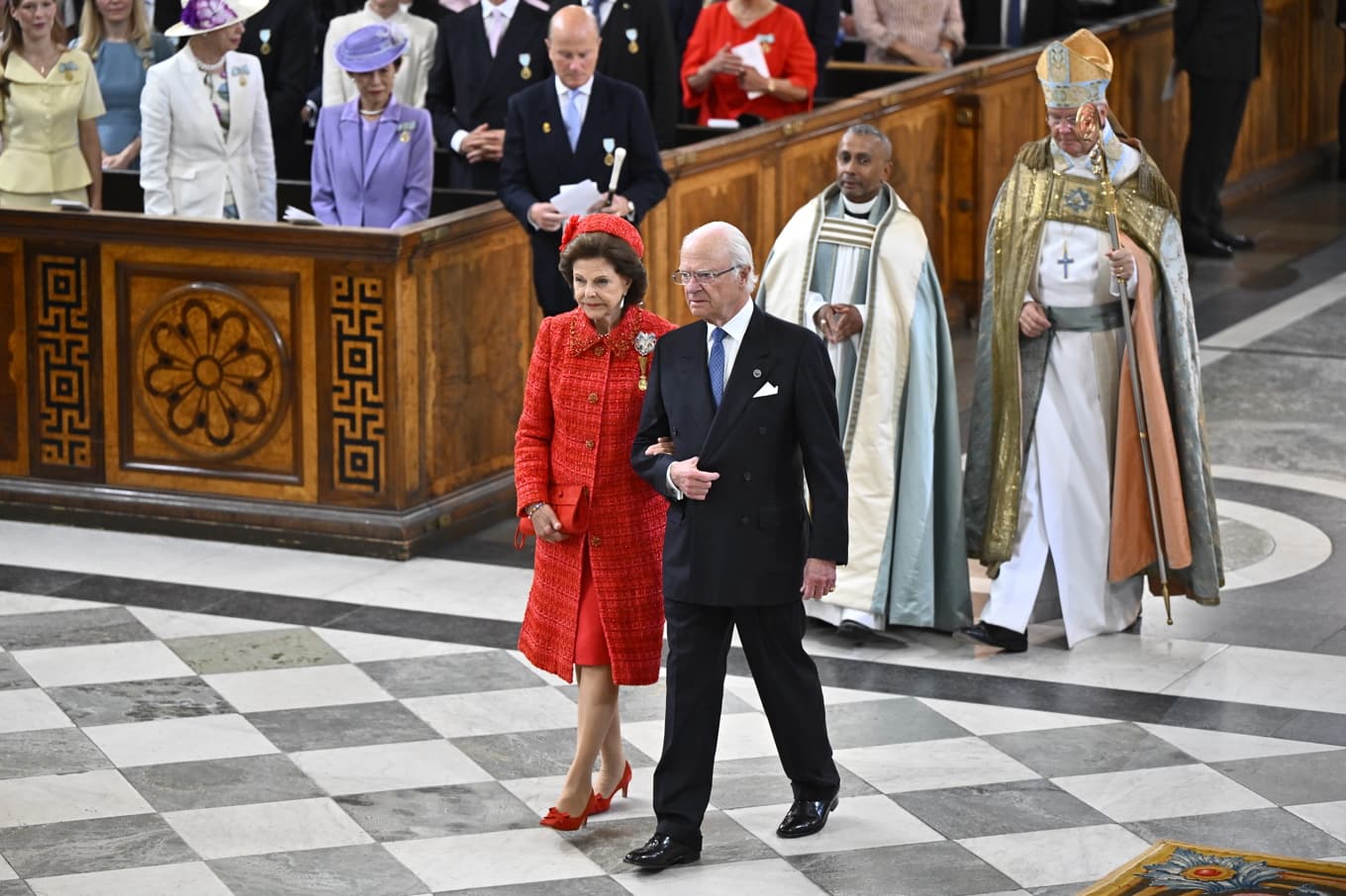 Guldbröllopsparet kung Carl Gustaf och drottning Silvia anländer till tacksägelsegudstjänsten Te Deum i Slottskyrkan i Stockholm. Bakom dem går samt hovpredikanterna Michael Bjerkhagen och Johan Dalman. Foto: Christine Olsson/TT