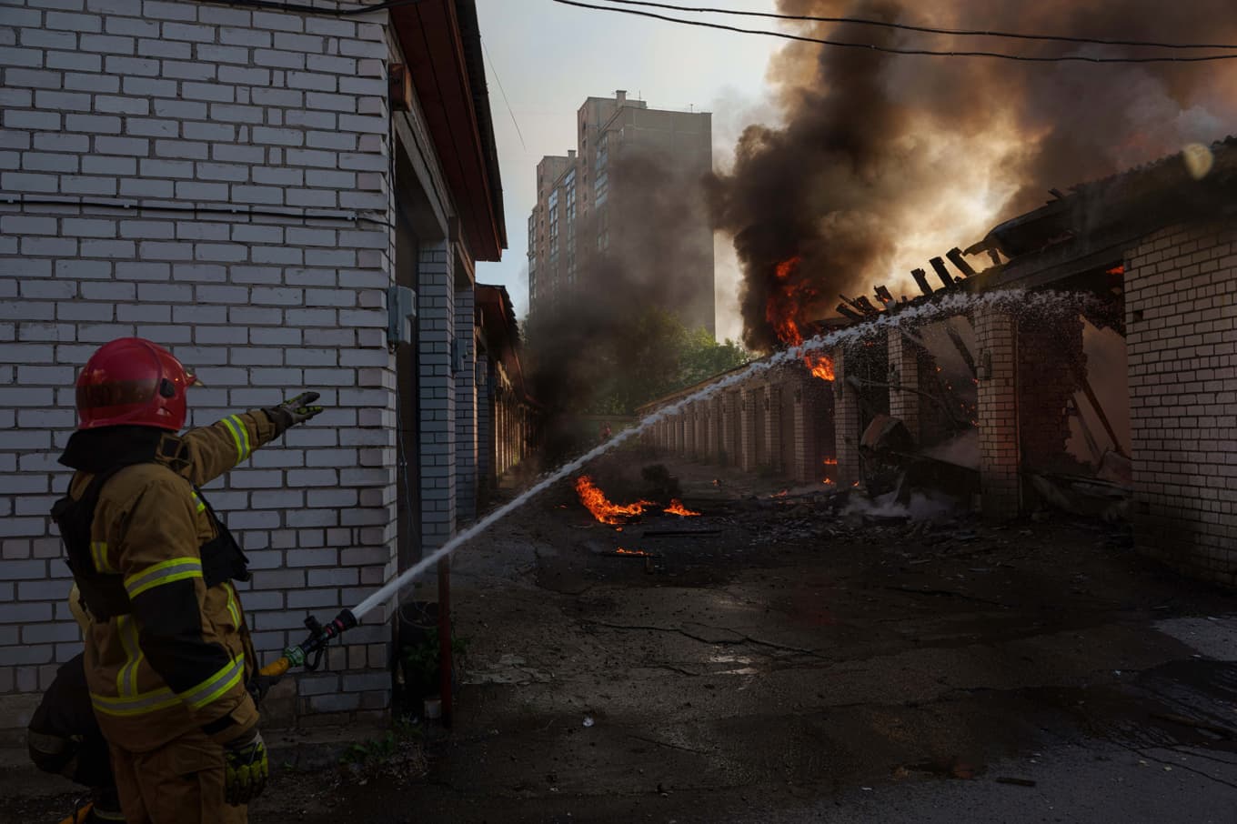Räddningsarbetare släcker en brand efter en rysk attack mot ukrainska Kiev i början på juni. Foto: Jevgenij Maloletka/AP/TT