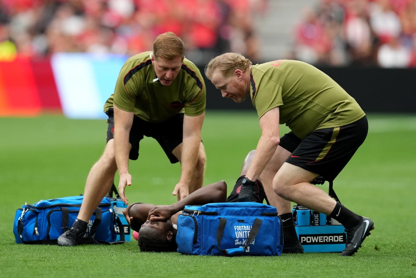 Kanadas Ismaël Koné får vård på planen efter skadan. Foto: Ethan Cairns/AP/TT