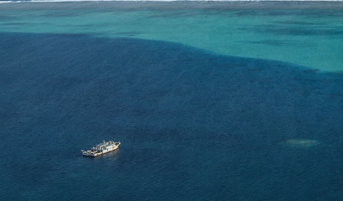 Fartyg som den filippinska kustbevakningen identifierat som tillhörande Kinas ”maritima milis” syns inne i lagunen vid Scarboroughrevet i Sydkinesiska havet under en flygspaning i fjol. Foto: Jam Sta Rosa/AFP via Getty Images