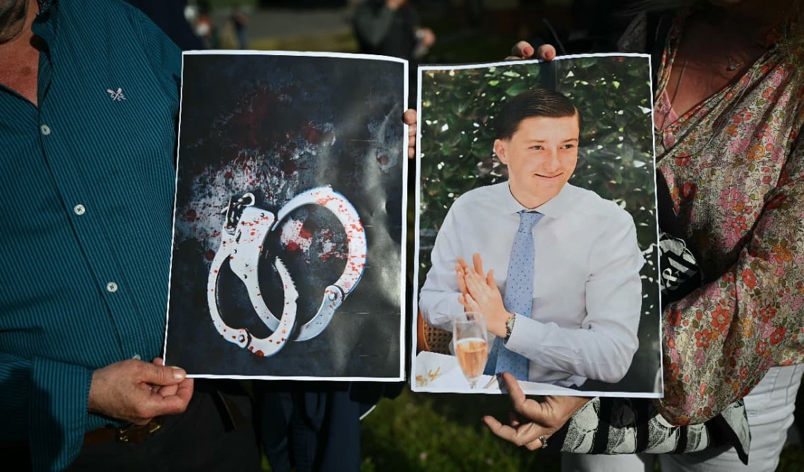 Människor håller upp bilder på 18-årige Henry Nowak och blodiga handbojor när de deltar i en demonstration utanför polisstationen i Southampton i södra England den 2 juni. Foto: Justin Tallis/AFP via Getty Images