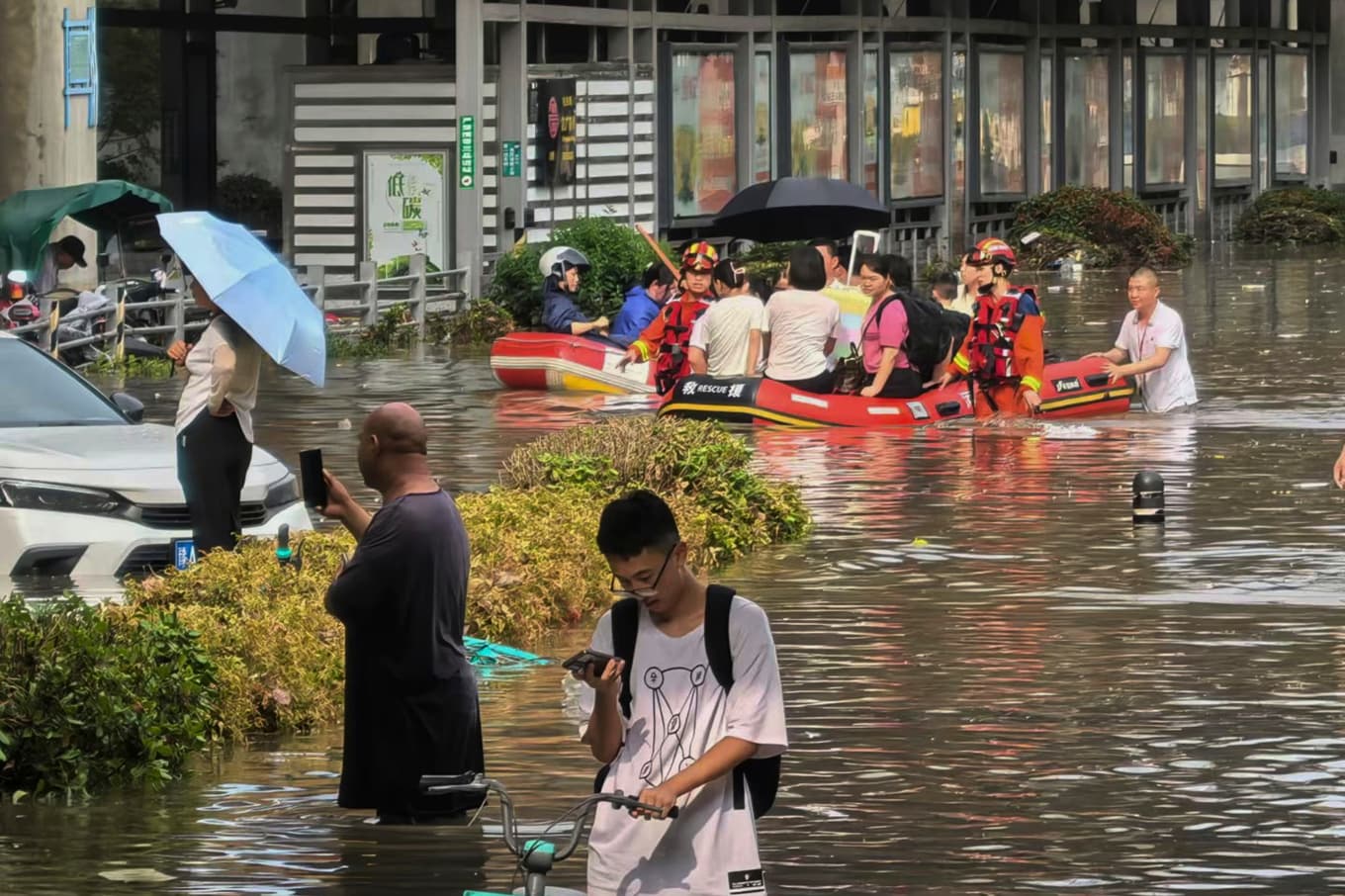 Räddningsarbetare i gummibåtar tar folk i säkerhet i Zhengzhou, centrala Kina, i tisdags. Foto: Chinatopix/AP/TT