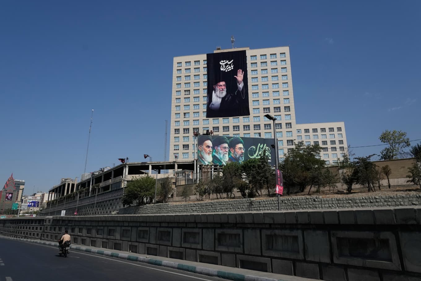 En affisch på ayatollah Ali Khamenei, som dödades i början av kriget, hänger på en byggnad i Teheran. Foto: Vahid Salemi  /AP/TT