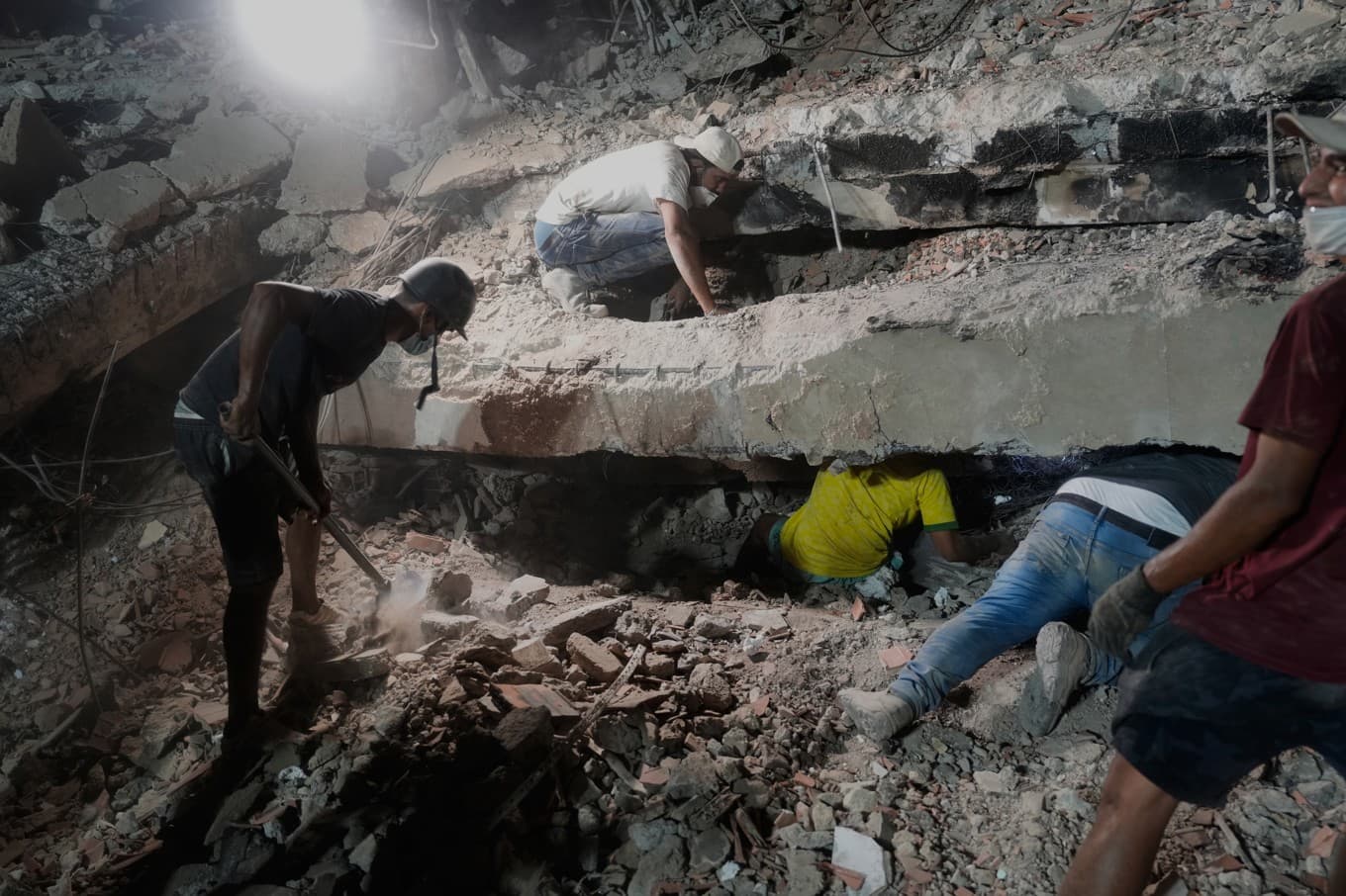 En familj letar efter anhöriga under rasmassorna i La Guaira, den 9 juli. Foto: Ariana Cubillos  /AP/TT