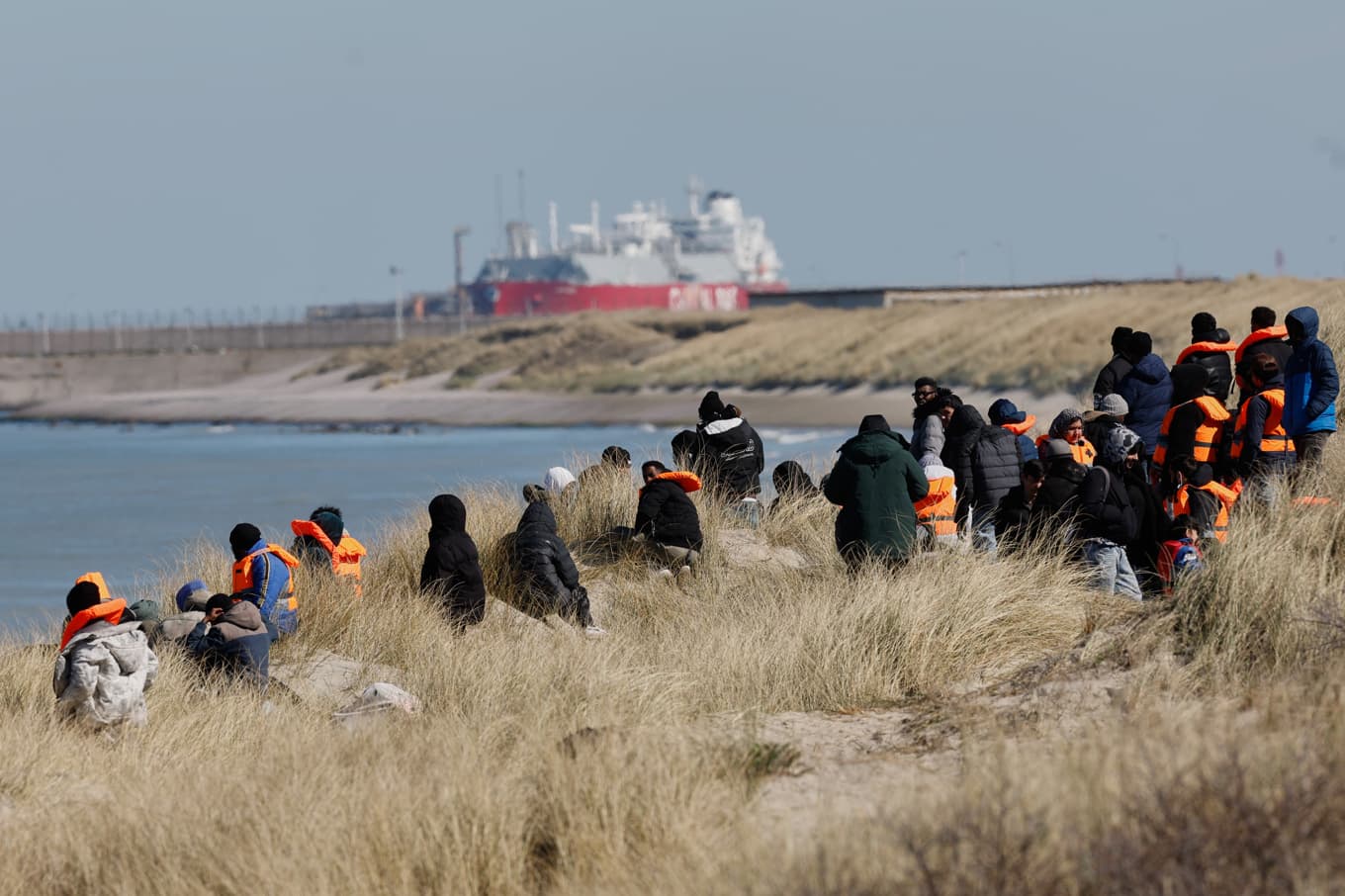 Migranter som ska försöka ta sig till Storbritannien väntar på en strand i Gravelines i norra Frankrike. Arkivbild Foto: Jean-Francois Badias/AP/TT