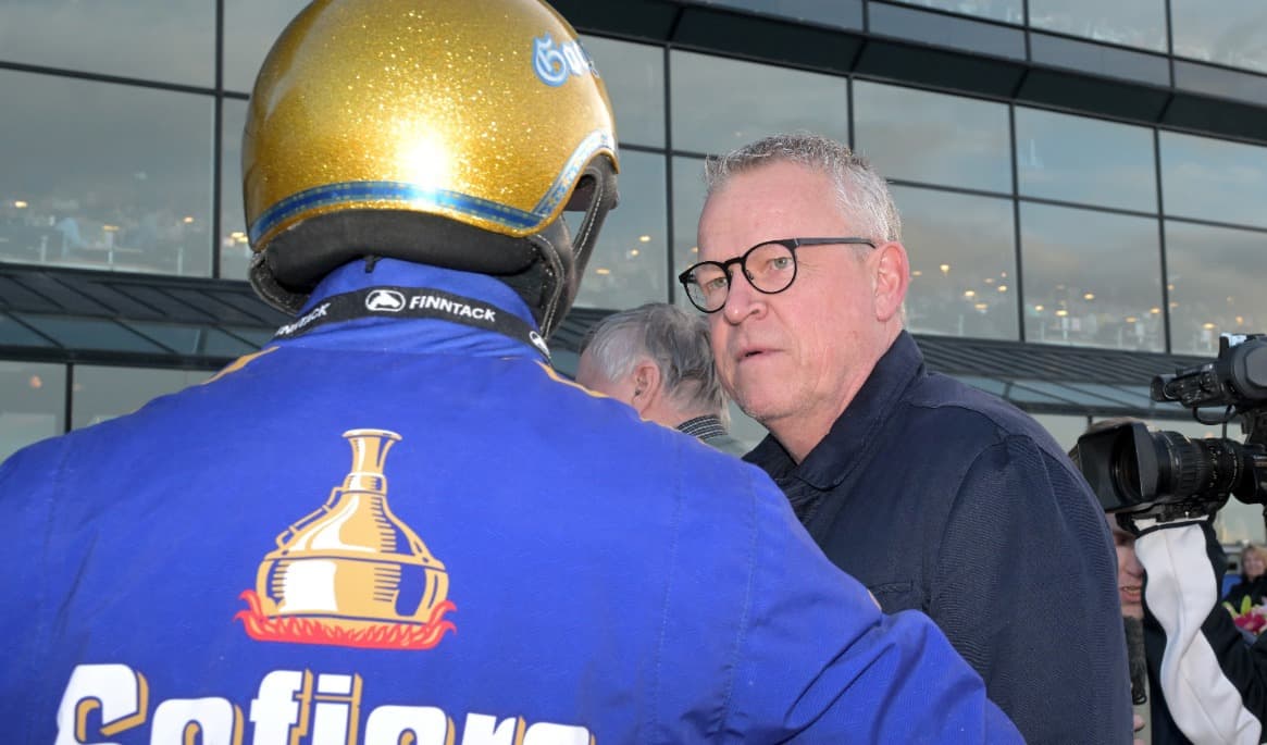 Fotbollstränaren Janne Andersson på travbanan i samspråk med Björn Goop, som har ryggen mot kameran. Foto: Lars Jakobsson / TR Bild
