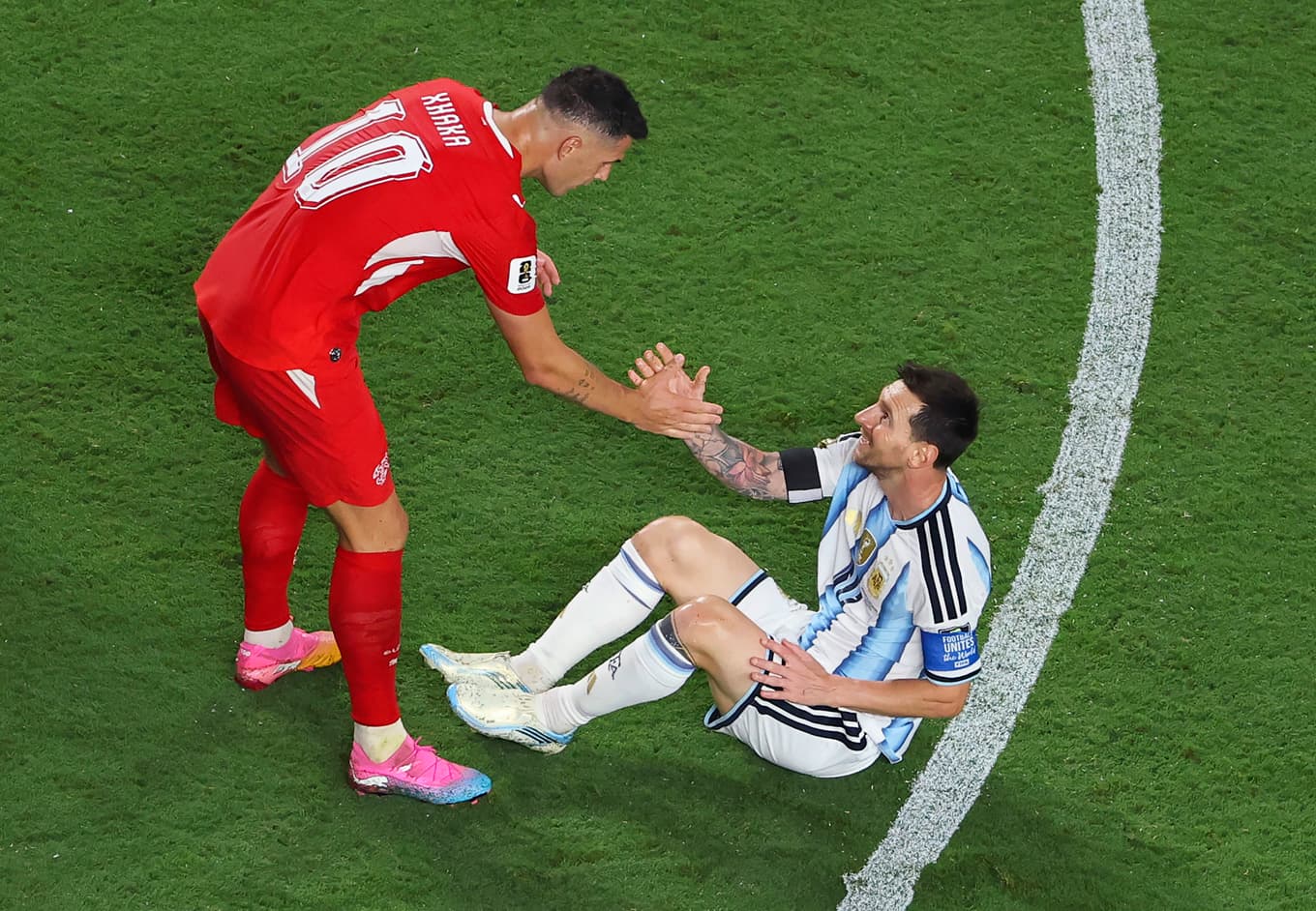 Granit Xhaka, nummer 10 i Schweiz, hjälper Lionel Messi, nummer 10 i Argentina, upp under kvartsfinalmatchen i fotbolls-VM 2026 på Kansas City Stadium. Foto: Luke Hales/Getty Images