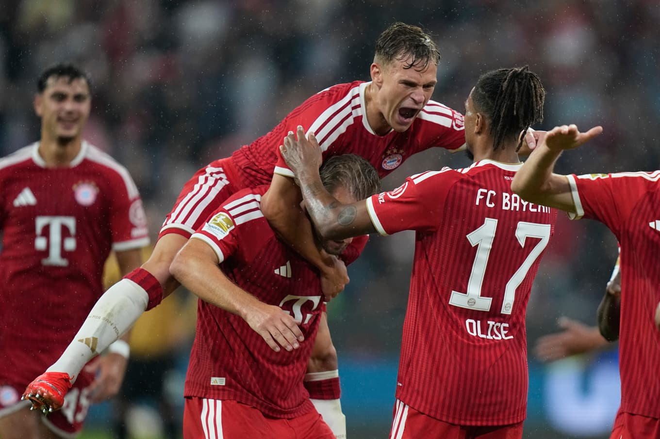 Bayern München-spelarna Michael Olise, Joshua Kimmich, och Harry Kane firar under Bundesligapremiären mot Stuttgart. Foto: Matthias Schrader/AP/TT