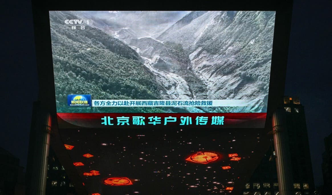 Statliga CCTV visar ett klipp från lerskredet på storskärm i Peking. Informationen har kontrollerats hårt i Kina. Foto: Greg Baker / AFP via Getty Images