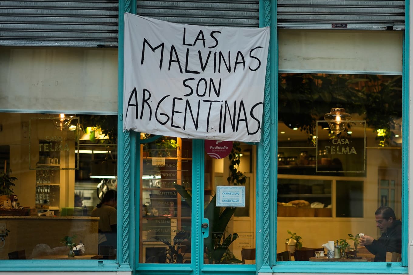 ”Las Malvinas är argentinska”, lyder en banderoll på en restaurang i Buenos Aires. Islas Malvinas är det spanska namnet på Falklandsöarna. Foto: Natacha Pisarenko/AP/TT