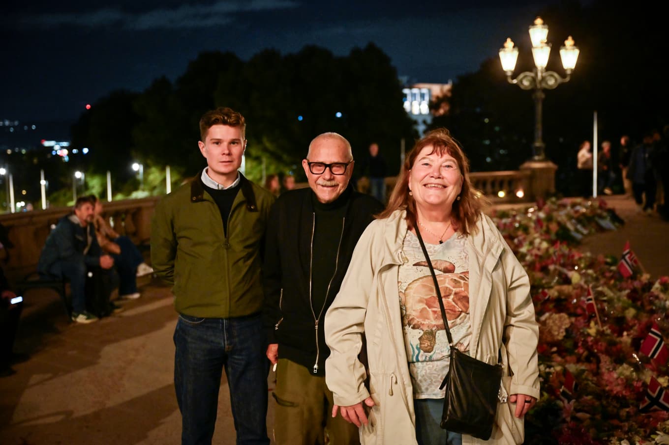 Osloborna Hans Bjørner, Sigmund Norderhos och Hilde Østrem vid blomsterhavet utanför kungliga slottet i Oslo kvällen inför begravningen. Foto: Pontus Lundahl/TT