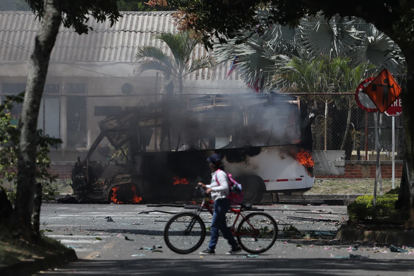 En buss brinner efter en explosion vid en militärbas i Cali i Colombia i april i år. Foto: Santiago Saldariaga/AP/TT
