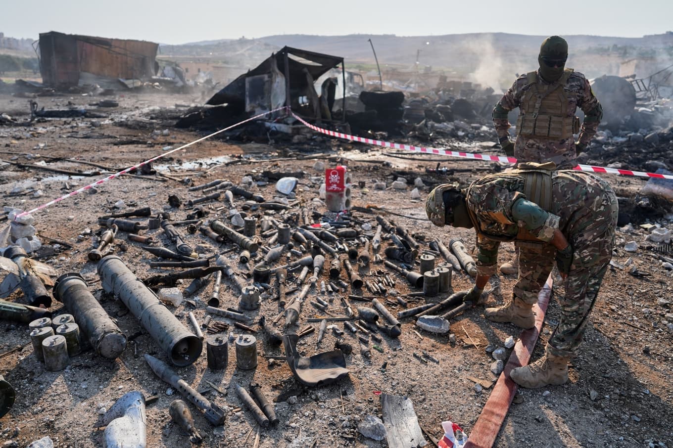 Säkerhetsstyrkor i Syrien granskar platsen för en svår explosion som inträffade i ett vapenförråd för knappt två veckor sedan. Arkivbild. Foto: Omar Albam /AP/TT