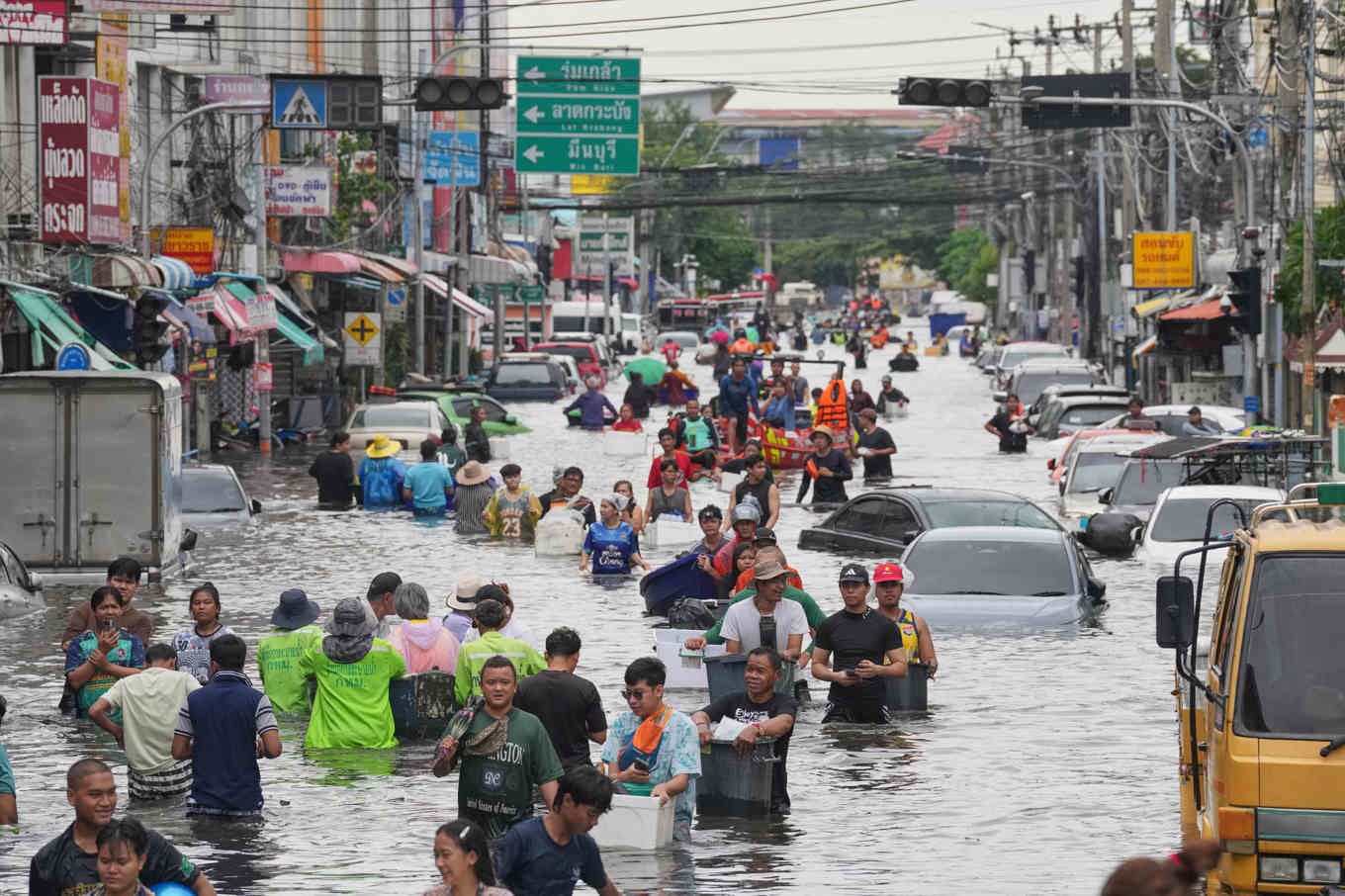 Människor vadar genom en översvämmad gata i Thailands huvudstad Bangkok. Foto: Sakchai Lalit/AP/TT