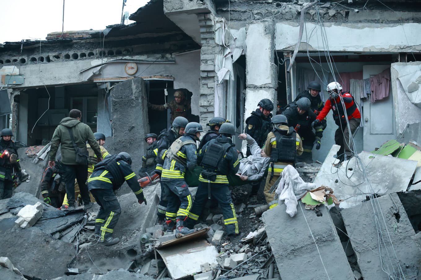 Räddningsarbetare hjälper en kvinna ur rasmassorna i Zaporizjzja. Foto: Kateryna Klochko/AP/TT