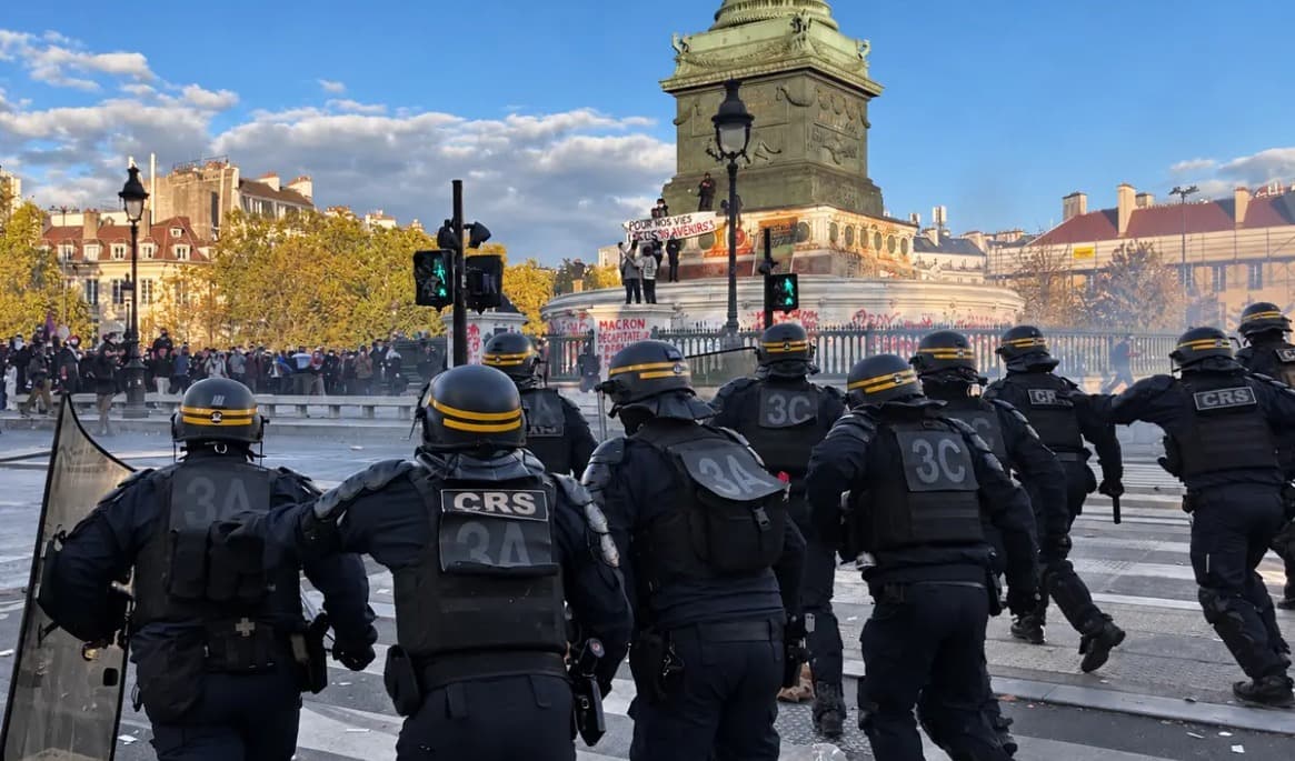 Fransk kravallpolis avancerar mot demonstranter i moln av tårgas på Place de la Bastille den 8 oktober. Foto: Etienne Fauchaire